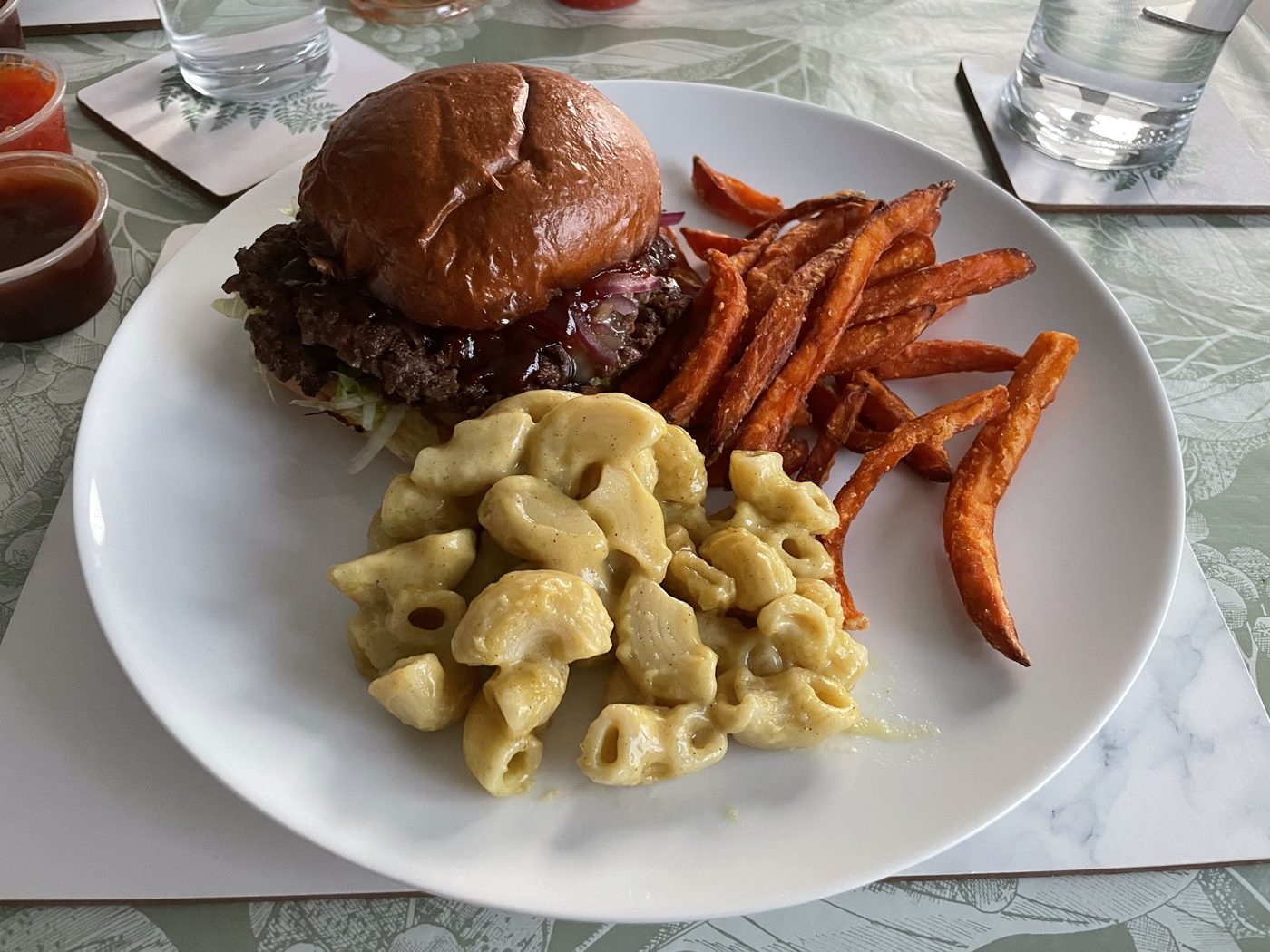 A burger with sweet potato fries and mac and cheese