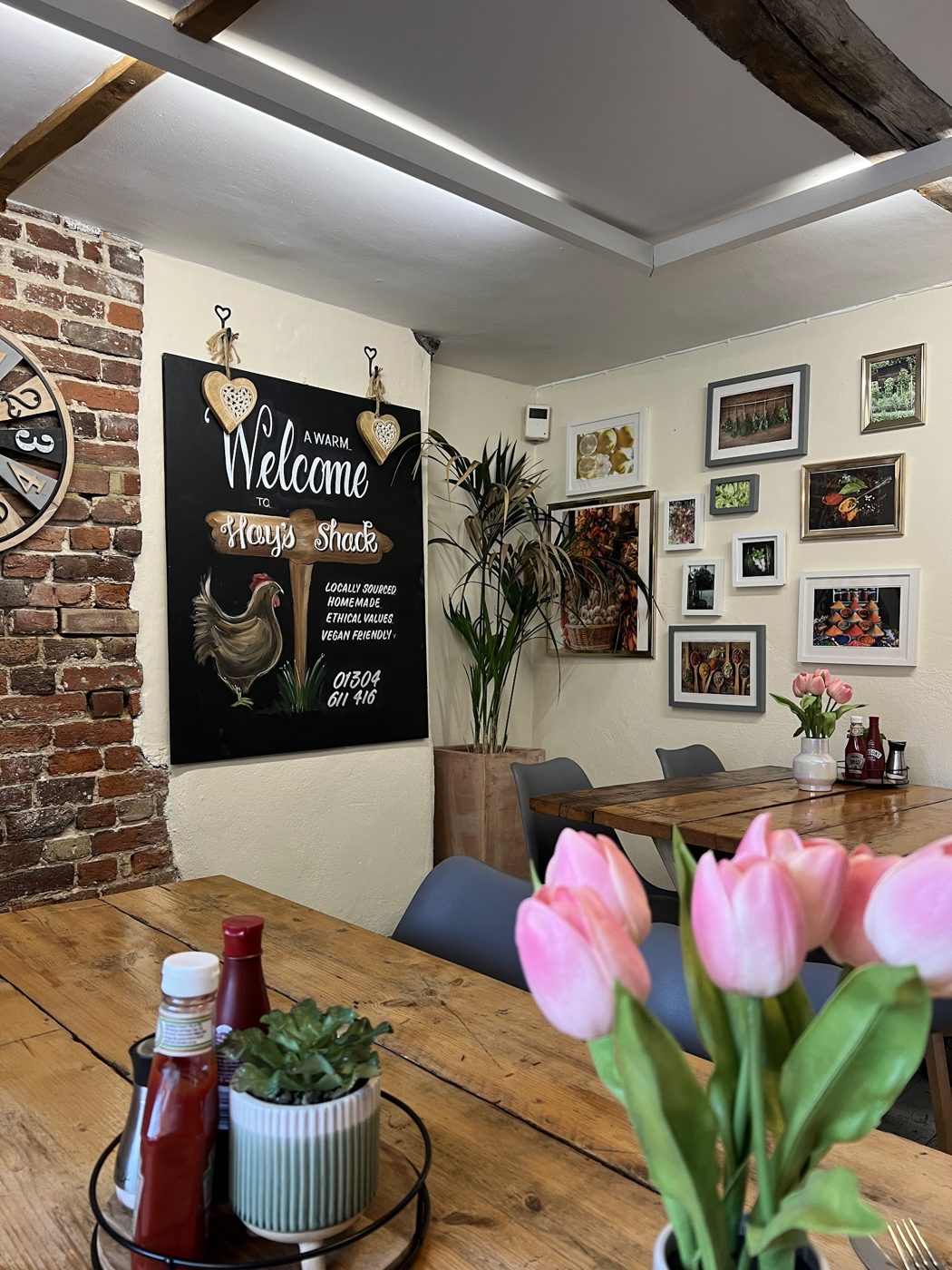 Inside, with a Welcome chalkboard, framed pictures and tulips on the table