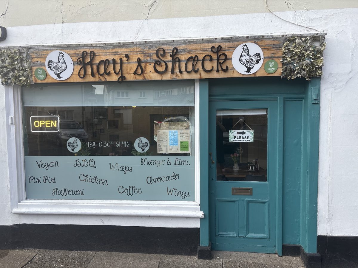 The white shopfront with a teal door and the Hay’s Shack sign